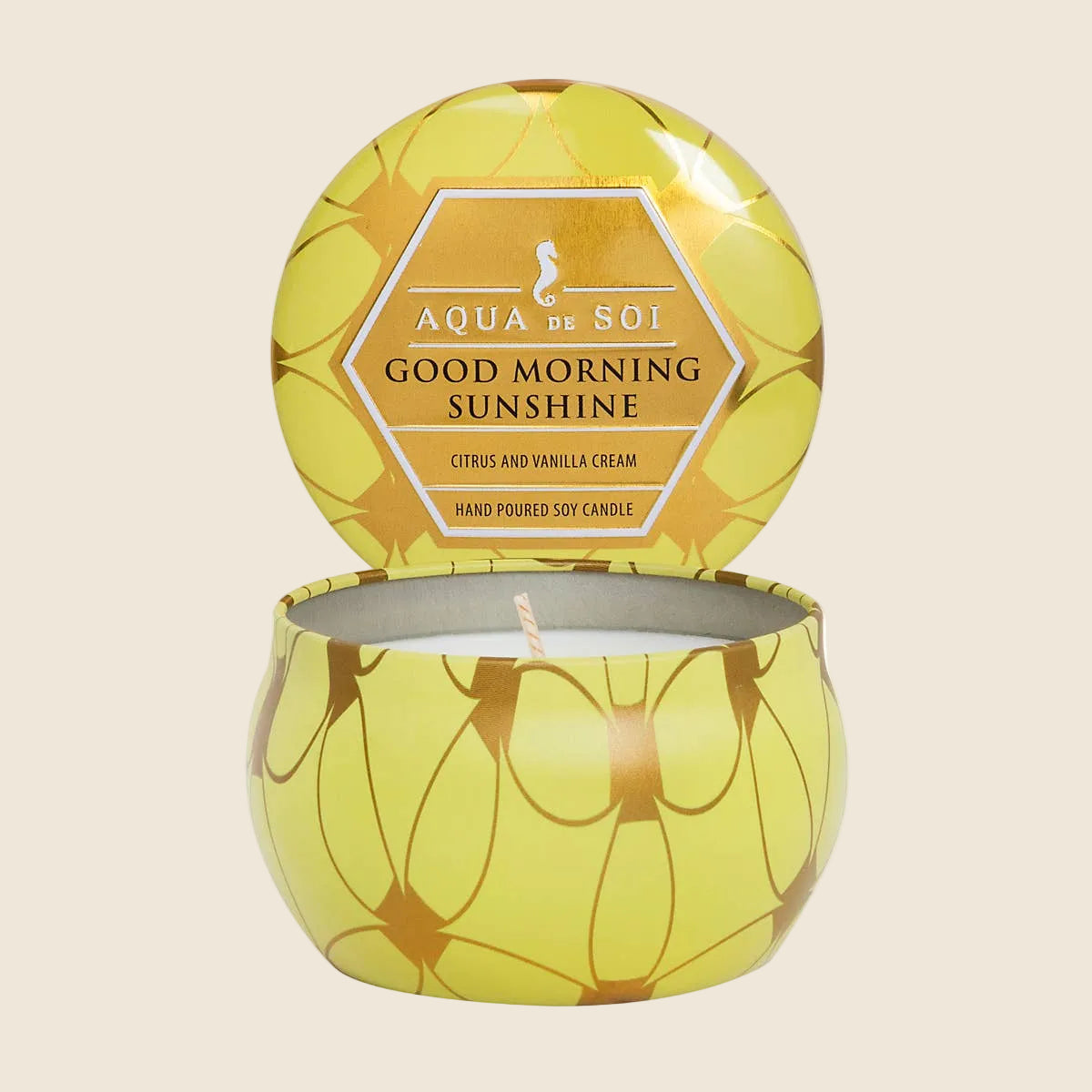 Yellow candle with decorative lid on a white background