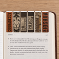 Six magnetic bookmarks with engraved Bible verses and a lion illustration, shown inserted into an open Bible on a light wood surface, by Christian Art Gifts.