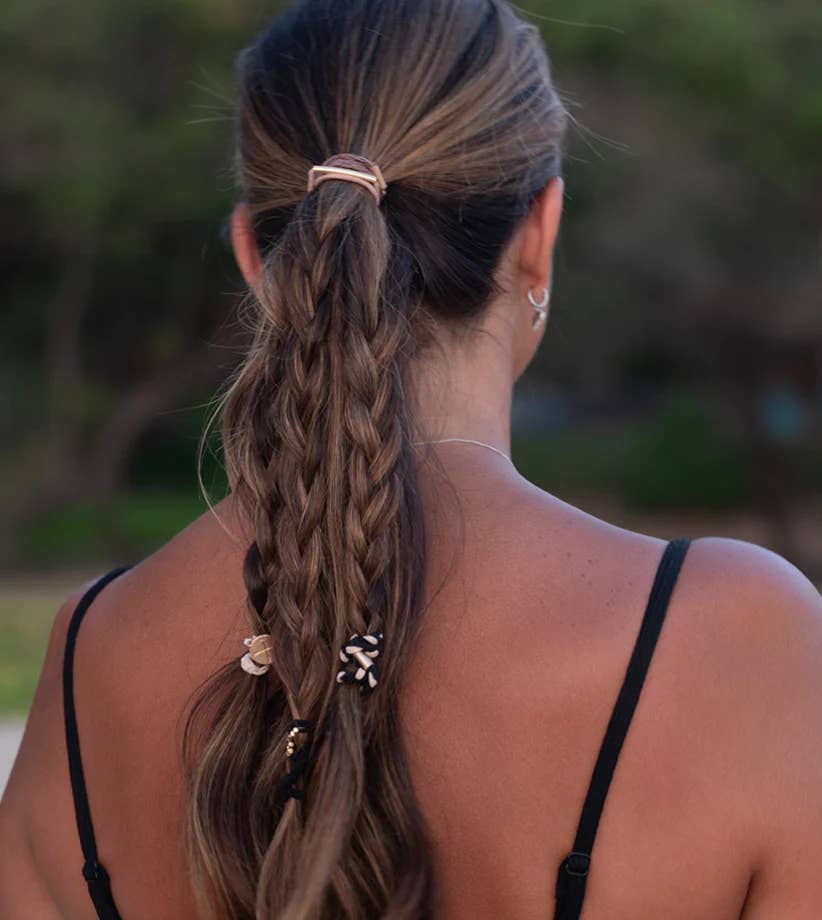 Person with braided hair wearing multiple K'Lani hairties.