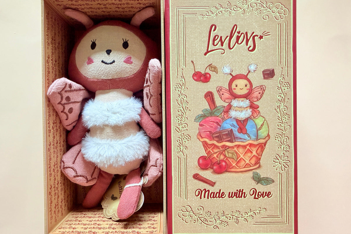 A pink and brown bunny plush toy with a white fluffy belly, displayed inside its open gift box next to the illustrated closed lid. The box lid features the brand name 'Levi's' and the text 'Made with Love' on a beige background with red borders.